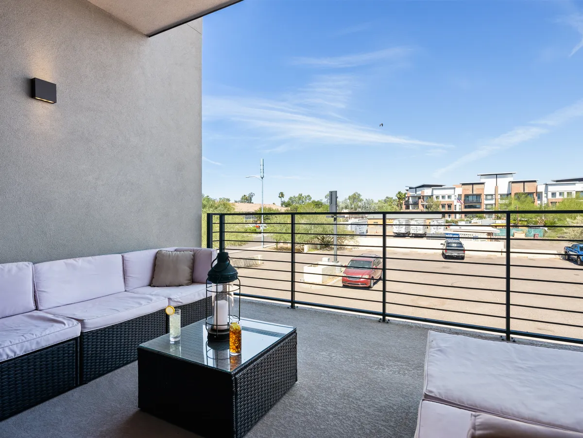 An inviting exterior seating area with a glass coffee table and lantern, set against a backdrop of open sky. The arrangement is perfect for group discussions, brainstorming sessions, or simply enjoying the sunset, embodying both productivity and leisure.