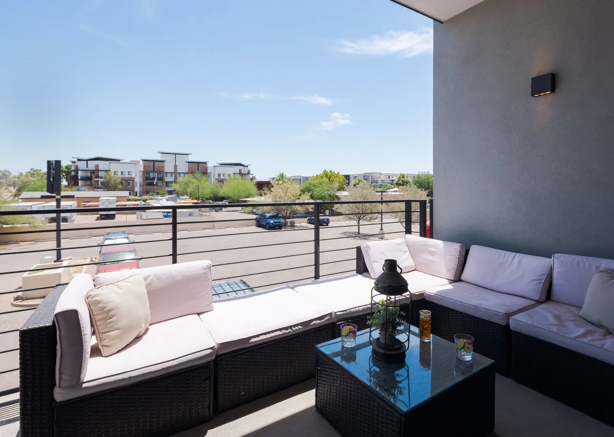 An outdoor seating area features a cozy arrangement with a coffee table and scenic landscape views, ideal for gatherings or quiet moments. The setting captures the feel of a tranquil oasis for families and pets to enjoy the outdoors together.